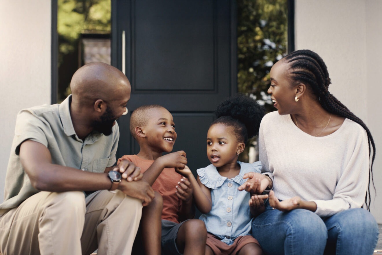 Black family, happy and talking on the porch with children for bonding, playing or conversation. Smile, relax and an African mother, father and kids outdoor for communication or speaking together